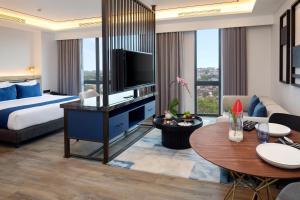 三宝垄Hotel Aruss Semarang的酒店客房设有一张特大号床和一间客厅。
