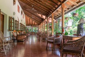 安巴拉瓦亚尔Tranquil Resort - Blusalzz Collection, Wayanad - Kerala的大楼内带桌椅的长走廊