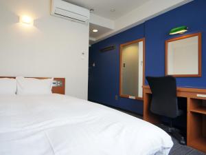 熊本银座通酒店的一间卧室配有一张床和一张带电脑的书桌