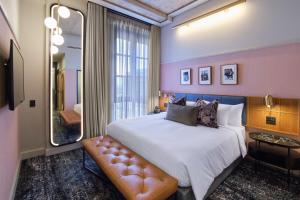 约翰内斯堡voco Johannesburg Rosebank an IHG Hotel的一间卧室配有一张大床和镜子