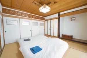 旭川Maple Farm的一间卧室配有一张白色的床,上面有蓝色的毛巾