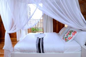 恩德培Pelican Lodge & Marina的一间卧室配有一张带天蓬的白色床