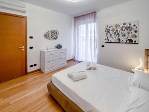 萨沃纳Nuovo bilocale nel porto antico的白色卧室设有一张大床和一个梳妆台