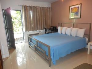 迈阿密夏利马尔汽车旅馆的一间卧室配有一张带蓝色毯子的大床