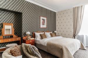 克拉科夫Hotel H15 Francuski Old Town - Destigo Hotels的一间卧室配有一张床、一把椅子和镜子