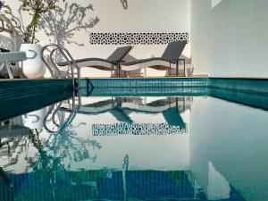 拉巴特达山摩洛哥传统庭院住宅的游泳池旁设有两把椅子