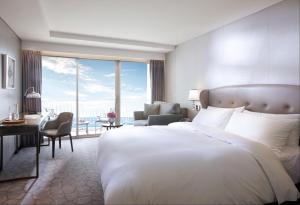 釜山百乐达斯釜山酒店的一间带大床的卧室和一间享有美景的客厅