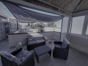 吉诺萨滨海Casa vacanza Leone con Terrazza的阳台配有椅子、床和桌子