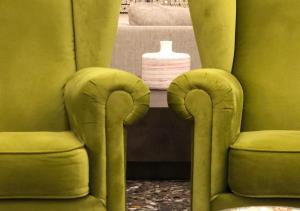 菲乌吉圣乔治酒店的浴室设有两把绿色椅子和白色花瓶