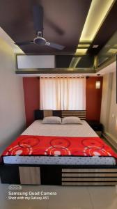 马迪凯里Varam Homestay的一间卧室配有一张带红色毯子的床