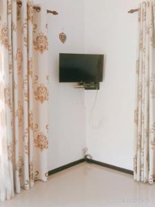 米迪加马东Romaclan Villa的窗帘间配有平面电视