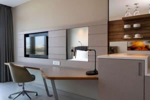 马普托马普托丽笙酒店的一个带书桌和镜子的家庭办公室