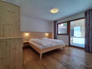 布列瑟农Zimmererhof的一间卧室设有一张床和一个大窗户