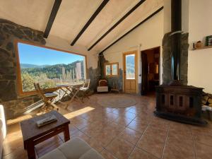 里奥帕尔Casa Rural El Carrizal的客厅设有壁炉和大窗户。