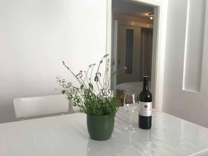 多瑙河畔克雷姆斯Gästehaus Lurger的一瓶葡萄酒和一瓶花瓶植物
