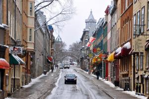 魁北克市奥伯格圣路易斯酒店的一辆汽车沿着雪覆盖的街道行驶