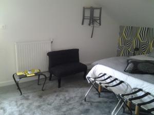 默兹河畔凡尔登La Maison Mirabeau的一间卧室配有一张床和一把椅子