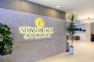 西归浦市Shin Shin Hotel Jeju Worldcup的杰居工作区闪烁的标志