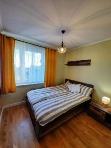 BielinyDomek Przy Osadzie的一间卧室设有一张大床和一个窗户。