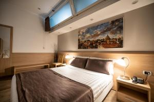 罗马保罗II号酒店的卧室配有一张床,墙上挂着一幅大画