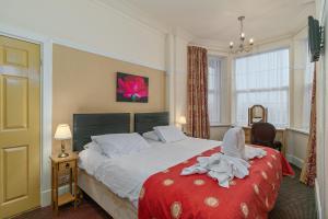 斯凯格内斯皇家酒店的一间卧室配有一张带红色毯子的大床