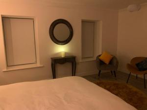 韦斯特波特Alta House的一间卧室配有一张床、镜子和椅子