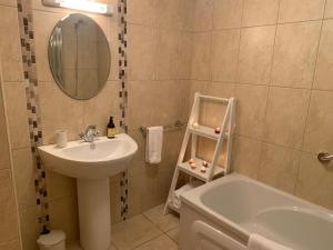 韦斯特波特Alta House的浴室配有盥洗盆、卫生间和浴缸。