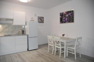 热舒夫Apartament nad fontanną的厨房配有白色的桌子和白色的椅子