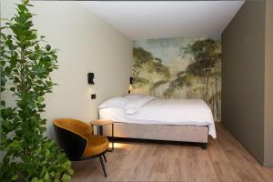 巴斯托涅Appart hôtel En Ville的卧室配有一张床,墙上挂有绘画作品