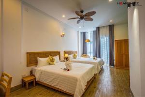 Phường SáuViva Hotel Phú Yên的一间卧室配有两张床和吊扇