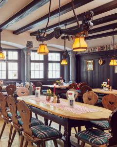 林道恩格尔林道尔啤酒和葡萄酒酒吧酒店的餐厅设有一张大型木桌和椅子