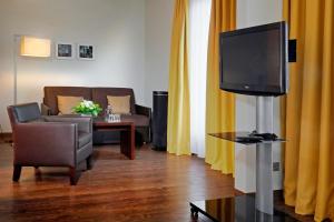 美因河畔法兰克福弗里德博格瓦特贝斯特韦斯特高级IB酒店的一间带电视和沙发的客厅