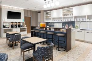 夏洛特Hyatt Place Charlotte University的厨房设有酒吧和桌椅