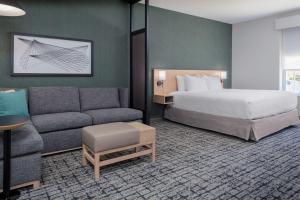 夏洛特Hyatt Place Charlotte University的酒店客房,配有床和沙发