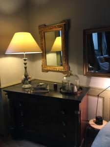 蓬塔利耶科特迪瓦庄园旅馆的一间卧室配有带台灯和镜子的梳妆台