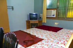KīhīmNanndi Holiday stay的一间卧室配有一张床和一张桌子上的电视