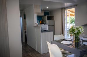 FoulerotMobil Home XXL 4 chambres - Camping Le Domaine d'Oléron的厨房以及带桌椅的用餐室。