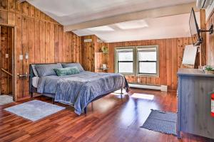 普雷斯科特Prescott Home with Deck and Grill Close to Hiking!的卧室配有一张床铺,位于带木墙的房间内