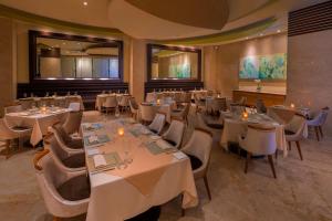坎昆Beach Palace - All Inclusive的一间在房间内配有桌椅的餐厅