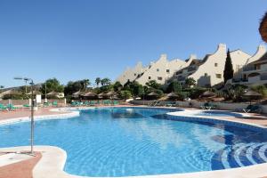 阿塔玛丽亚La Manga Club Resort - Los Olivos 54的度假村的游泳池,配有椅子和遮阳伞
