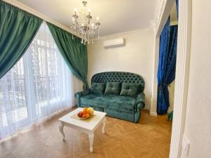 丰坦卡Kikasso Art Apart Odessa的客厅配有绿色沙发和桌子