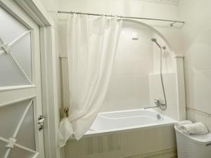 丰坦卡Kikasso Art Apart Odessa的浴室内设有带浴帘的白色浴缸