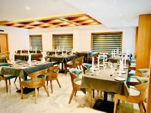 德里久尔MothiMahal Residency Thrissur的用餐室设有桌椅和窗户。
