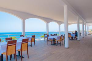 Pedra BadejoFalucho Paradise Beach的一间设有桌椅的海洋餐厅