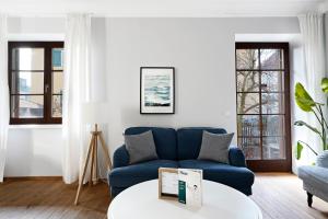 萨尔茨堡numa I Flute Apartments的客厅配有蓝色的沙发和桌子