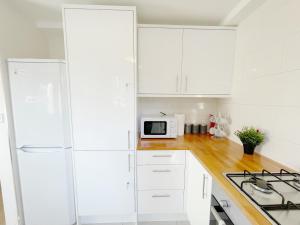 牛津Oxford city centre house/walkable to University的白色的厨房配有白色橱柜和白色冰箱