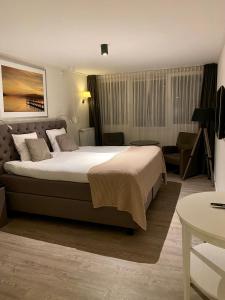 洪德洛布腾拉斯特酒店的酒店客房带一张大床和一把椅子