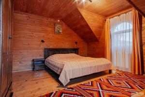 瓦马Floarea Bucovinei的木制客房内的一间卧室,配有一张床