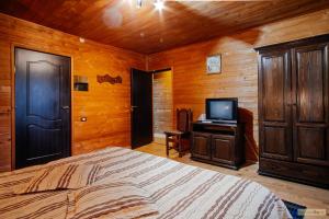 瓦马Floarea Bucovinei的一间卧室配有一张床和一台电视