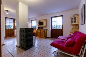 坎皮泰洛El Tobià的一间带红色沙发的客厅和一间厨房